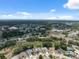 Wide aerial view of homes and roads, neighborhood amenities, commercial development and wooded areas in the area at 9104 Water Hazard Dr, Hudson, FL 34667