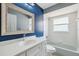 This bathroom features a blue accent wall, a large mirror, and a tub with shower at 9104 Water Hazard Dr, Hudson, FL 34667