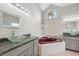 Bathroom with double vanities, a corner soaking tub, and a window that offers natural light at 9104 Water Hazard Dr, Hudson, FL 34667