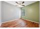 This bedroom features hardwood floors, a ceiling fan, and a window for natural light at 9104 Water Hazard Dr, Hudson, FL 34667