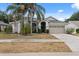 Charming home featuring a two-car garage, mature landscaping, and a well-manicured lawn at 9104 Water Hazard Dr, Hudson, FL 34667