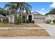 Charming home featuring a two-car garage, mature landscaping, and a well-manicured lawn at 9104 Water Hazard Dr, Hudson, FL 34667