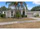 Charming home featuring a two-car garage, mature landscaping, and a well-manicured lawn at 9104 Water Hazard Dr, Hudson, FL 34667
