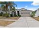 Charming home featuring a two-car garage, mature landscaping, and a well-manicured lawn at 9104 Water Hazard Dr, Hudson, FL 34667