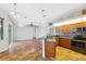 Open kitchen layout with modern appliances, breakfast bar, and views into the living room and outdoor pool area at 9104 Water Hazard Dr, Hudson, FL 34667