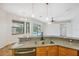 Modern kitchen with stainless steel appliances, granite countertops, and view to pool at 9104 Water Hazard Dr, Hudson, FL 34667