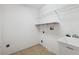 This laundry room features tile floors, utility sink, and shelving for storage at 9104 Water Hazard Dr, Hudson, FL 34667