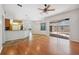 Open floor plan with wood floors that connects the kitchen, living room, and screened-in patio at 9104 Water Hazard Dr, Hudson, FL 34667
