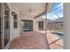 This covered patio features brick pavers, access to the pool, and sliding glass doors at 9104 Water Hazard Dr, Hudson, FL 34667