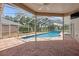 This pool area features a screened enclosure, brick pavers, and a clear blue pool at 9104 Water Hazard Dr, Hudson, FL 34667