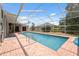 A screened in pool with brick decking offers a refreshing oasis for relaxation and entertainment at 9104 Water Hazard Dr, Hudson, FL 34667