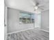 This bedroom has a ceiling fan, window, and new vinyl flooring for easy maintenance at 9141 Greenbriar Ln, Port Richey, FL 34668