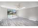 Bright bedroom with luxury vinyl floors and large sliding glass doors leading to a pool at 9141 Greenbriar Ln, Port Richey, FL 34668