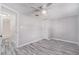 Bright bedroom with wood-look floors and a glimpse into an adjoining bathroom at 9141 Greenbriar Ln, Port Richey, FL 34668