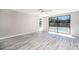 Spacious bedroom with luxury vinyl floors and large sliding glass doors leading to a pool at 9141 Greenbriar Ln, Port Richey, FL 34668