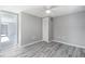 Spacious bedroom with wood-look floors, ceiling fan, and a closet for convenient storage at 9141 Greenbriar Ln, Port Richey, FL 34668