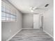 Light filled empty bedroom with a ceiling fan and hardwood floors at 9141 Greenbriar Ln, Port Richey, FL 34668