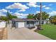 Charming single-story home with blue exterior, well-manicured lawn, and long driveway at 9141 Greenbriar Ln, Port Richey, FL 34668