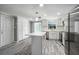 Modern kitchen featuring a center island, stainless steel appliances, white cabinetry, and ample storage at 9141 Greenbriar Ln, Port Richey, FL 34668