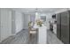 Contemporary kitchen with a central island, stainless steel appliances, and sleek white cabinetry at 9141 Greenbriar Ln, Port Richey, FL 34668