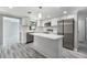 Bright kitchen features white cabinets, stainless steel appliances, and a stylish island with marble countertop at 9141 Greenbriar Ln, Port Richey, FL 34668