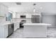 Bright and updated kitchen with stainless steel appliances, white cabinetry, and a center island at 9141 Greenbriar Ln, Port Richey, FL 34668