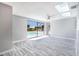 Bright living room with skylight and fan, featuring sliding glass doors that view the screened pool at 9141 Greenbriar Ln, Port Richey, FL 34668