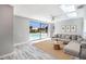 Bright living room featuring a skylight, ceiling fan, and sliding doors opening to a screened pool at 9141 Greenbriar Ln, Port Richey, FL 34668