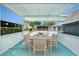 The covered patio features an outdoor dining area with direct views of the backyard pool at 9141 Greenbriar Ln, Port Richey, FL 34668