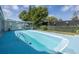 Large backyard pool with beautiful mature trees and a covered patio area for relaxing at 9141 Greenbriar Ln, Port Richey, FL 34668