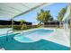 A serene backyard pool with well-maintained landscaping and a covered patio, creating a private oasis at 9141 Greenbriar Ln, Port Richey, FL 34668