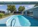 Backyard pool with a light blue deck, screened-in lanai, and easy access to the home through sliding glass doors at 9141 Greenbriar Ln, Port Richey, FL 34668