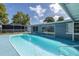 Backyard pool features a sunny blue deck, complemented by a screened-in lanai, perfect for relaxing at 9141 Greenbriar Ln, Port Richey, FL 34668