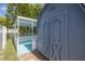 Exterior view of a backyard shed featuring a covered patio area and double doors for storage and accessibility at 9141 Greenbriar Ln, Port Richey, FL 34668