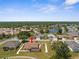 Aerial view of home with manicured lawn, landscaping, and serene neighborhood pond at 9208 Butler Blvd, Weeki Wachee, FL 34613