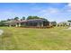 Spacious backyard featuring lush lawn, landscaping, and screened in back patio at 9208 Butler Blvd, Weeki Wachee, FL 34613