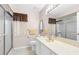 Well-lit bathroom featuring a shower with glass door, toilet, and white sink vanity at 9208 Butler Blvd, Weeki Wachee, FL 34613