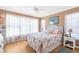 Bright bedroom with a colorful bedspread, two windows, and light colored flooring at 9208 Butler Blvd, Weeki Wachee, FL 34613