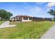 Well-maintained home exterior showcasing lush lawn, landscaping, and an enclosed patio at 9208 Butler Blvd, Weeki Wachee, FL 34613