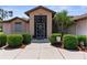 Close-up of front door featuring a unique design and manicured shrubs at 9208 Butler Blvd, Weeki Wachee, FL 34613