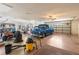 Spacious garage featuring a car, golf cart, storage, and bright lighting at 9208 Butler Blvd, Weeki Wachee, FL 34613