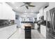 Bright kitchen with white cabinets, black granite countertops, stainless appliances, and a center island workstation at 9208 Butler Blvd, Weeki Wachee, FL 34613