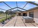 The covered outdoor patio has a screened enclosure, pavers, grill, and furniture for entertaining with golf course views at 9208 Butler Blvd, Weeki Wachee, FL 34613