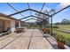 The large outdoor patio with hot tub has a screen enclosure and paver flooring with a view of the golf course at 9208 Butler Blvd, Weeki Wachee, FL 34613