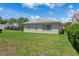 Spacious backyard with lush green grass and mature landscaping surrounding the home at 9400 New Orleans Dr, Weeki Wachee, FL 34613