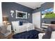 Cozy bedroom with a comfortable bed, a stylish blue rug, and a TV reflecting an exterior view of the home at 9400 New Orleans Dr, Weeki Wachee, FL 34613