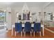 Elegant dining area with a large white table, blue chairs, and a view of the outdoor patio at 9400 New Orleans Dr, Weeki Wachee, FL 34613