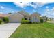 Inviting single-story home featuring a manicured lawn, trimmed hedges, and an attached two-car garage on a sunny day at 9400 New Orleans Dr, Weeki Wachee, FL 34613