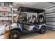 Garage featuring a modern golf cart, epoxy flooring, and shelving for organized storage at 9400 New Orleans Dr, Weeki Wachee, FL 34613