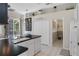 Bright kitchen features a black countertop, white cabinets, and access to the outdoor space at 9400 New Orleans Dr, Weeki Wachee, FL 34613